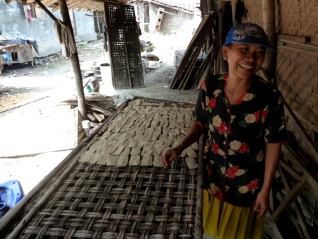 A woman has fun at work in a small rice cracker factory in Solo, Java. A woman has fun at work in a small rice cracker factory in Solo, Java.