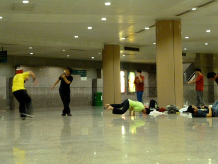 Some kids breakdance in a huge marble pedestrian underpass in City Centre, Singapoare.