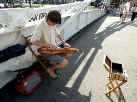 A street musician jams on the Cavenagh Bridge in Singapore.