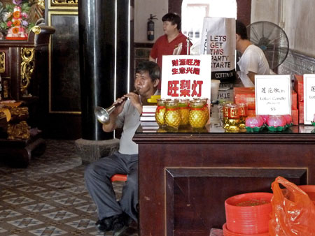 A horn player and a drummer on the right provide the music for a prayer service at the Thian Hock Keng Temple in Chinatown, Singapore.
