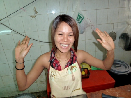 The cute food stall lady waves bye-bye. Chinatown, Kuala Lumpur, Malaysia.