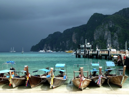 A row of longtail boats all lined up next to the pier on Ao Ton Sai Bay, Ko Phi Phi Don, Thailand.