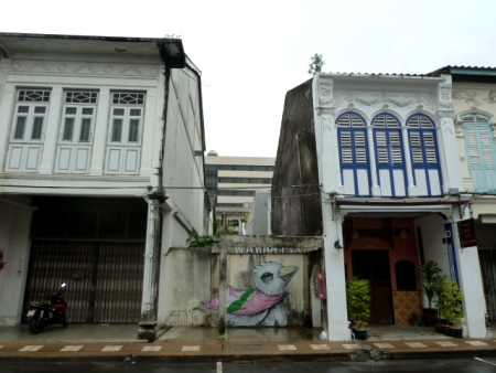 A big bird hangs out between two 19th century Sino-Portuguese shophouses in Phuket Town, Thailand. A big bird hangs out between two 19th century Sino-Portuguese shophouses in Phuket Town, Thailand.