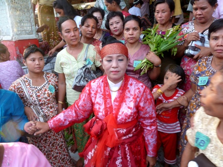 Post-performance, a nat kadaw exits the main temple with her entourage at the nat pwe in Taungbyone, Myanmar. Post-performance, a nat kadaw exits the main temple with her entourage at the nat pwe in Taungbyone, Myanmar.