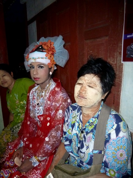 A nat kadaw and thanaka paste-covered woman make quite a pair at the nat pwe in Taungbyone, Myanmar. A nat kadaw and thanaka paste-covered woman make quite a pair at the nat pwe in Taungbyone, Myanmar.