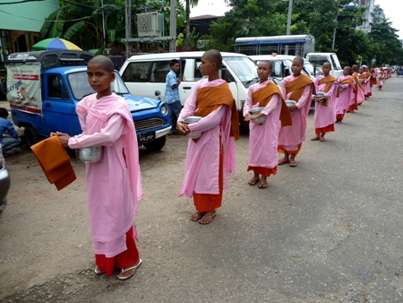 A procession of novice Buddhist nuns in front of the Motherland II Inn in Yangon, Myanmar. A procession of novice Buddhist nuns in front of the Motherland II Inn in Yangon, Myanmar.