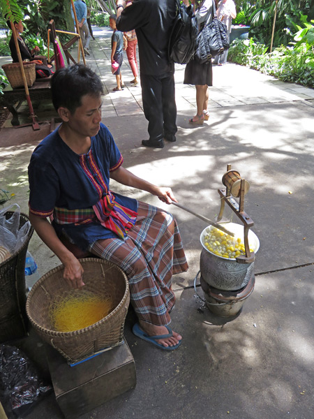 A man spools silk at Jim Thompson's House near Siam Square, Bangkok, Thailand.