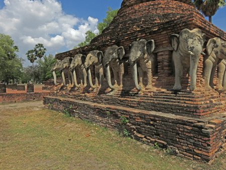 An elephant-ringed chedi at Wat Sorasak in Sukothai, Thailand.