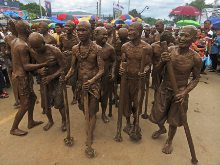 The mud men arrive on the scene in the parade at the Phi Ta Khon festival in Dan Sai, Thailand.