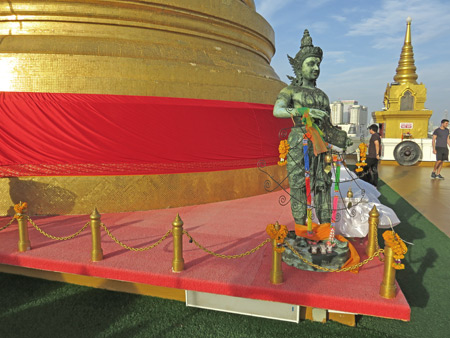 The huge golden chedi and a statue at the top of the Golden Mount in Bangkok, Thailand.