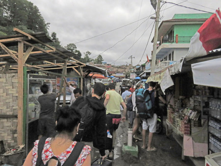 Heading in between the market stalls toward the share taxi in Parapat, Sumatra, Indonesia.