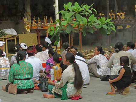 People sit at a small Hindu cremation ceremony in Penestanan, Ubud, Bali, Indonesia.