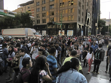 A massive amount of pedestrians crosses the street at the intersection of Avenues Madero and Cardenas in Mexico City, Mexico.
