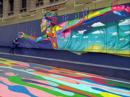 A pedestrian poses in front of a mural on Avenida Bandera in Santiago, Chile.
