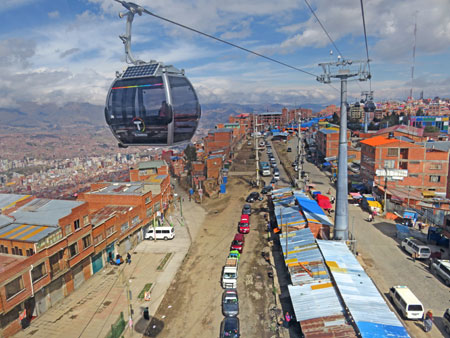 A cabin on the Mi Teleferico aerial cable car system transits over El Alto, Bolivia.