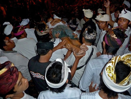 A body is carried to the stage at Pura Dalem Puri in Peliatan, Bali.