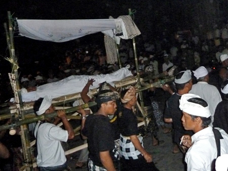 A procession of bodies from the stage to a temple for re-awakening at Pura Dalem Puri in Peliatan, Bali.