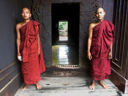 A pair of young Buddhist monks stand guard at Shwe In Bin Kyaung monastery in Mandalay, Myanmar.