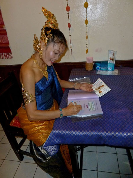 May Kaidee signs copies of her cookbook at her restaurant in Banglamphu, Bangkok, Thailand.