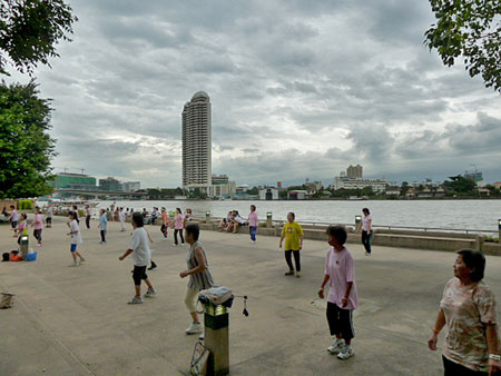 A late evening aerobics session steams full ahead at Santichaiprakan Park in front of the Chao Phraya river in Banglamphu, Bangkok, Thailand.