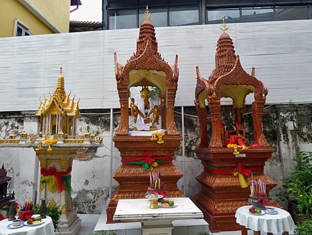 A couple of Thai spirit houses sit in front of a hotel on Thanon Khao San in Banglamphu, Bangkok, Thailand.