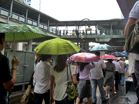 A procession of umbrellas in rainy Bangkok, Thailand.