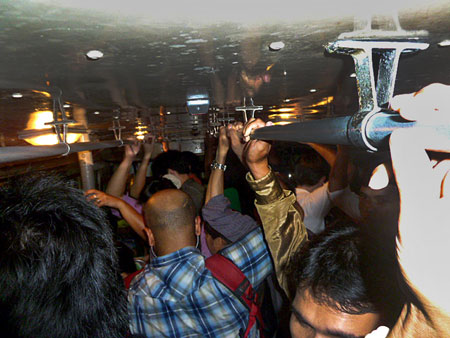 A packed night on bus 15 in Bangkok, Thailand.