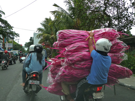 A big delivery makes its way on horseback, I mean motorcycle through Denpasar, Bali, Indonesia.