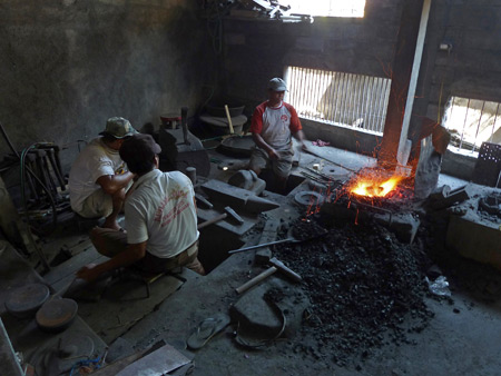 Workers forge a trompong gong at the Gong Surya Nada gamelan factory in Sawan, Bali, Indonesia.