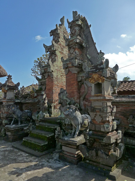 A Balinese Hindu temple gate with guardian boars in Peliatan, Bali, Indonesia.