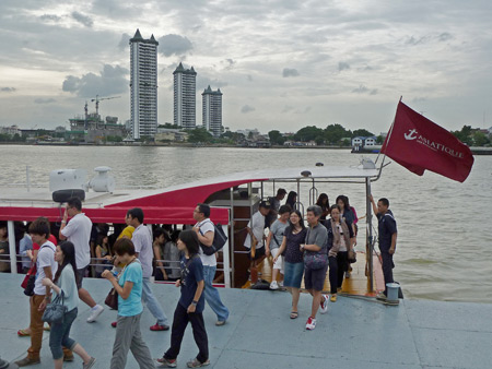 Passengers disembark from a Chao Phraya riverboat at Asiatique mall in Bangkok, Thailand.