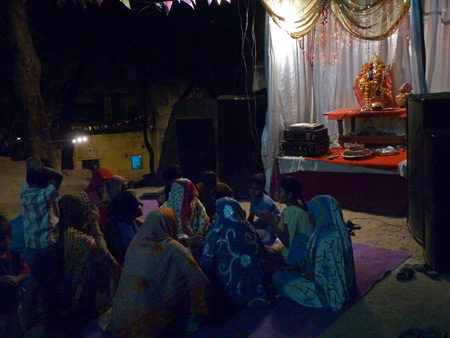 Women sing and play drums at a small Hindu shrine in Agra, India.