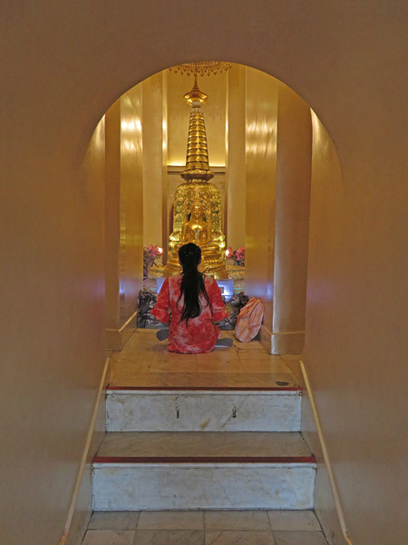 A devotee prays at a Buddha image in the center of the Golden Mount in Phra Nakhon, Bangkok, Thailand.