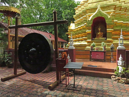 A large gong and a chedi at Wat Sareerikkatart Sirirak in Chiang Mai, Thailand.