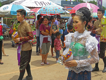 A beauty queen and her king walk in the parade at the Phi Ta Khon festival in Dan Sai, Thailand.
