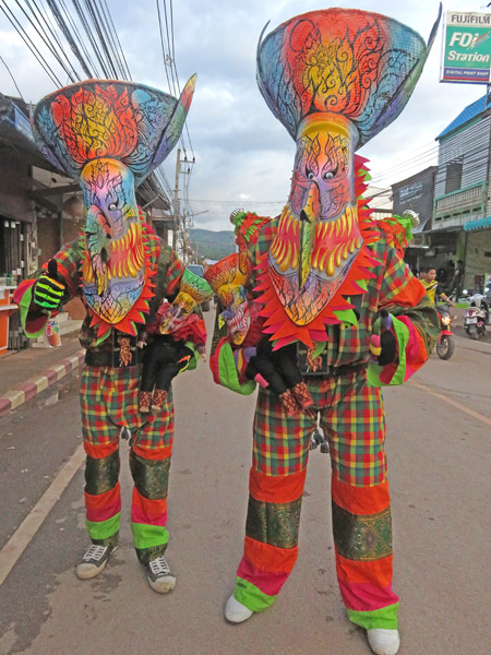 A pair of brightly clad ghosts say goodbye after the parade at the Phi Ta Khon festival in Dan Sai, Thailand.