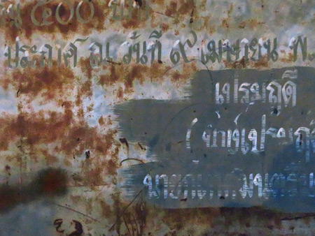 Thai writing and rust on a sign in Phitsanulok, Thailand.