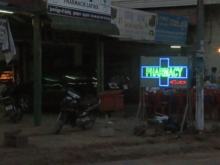 A poignant pharmacy sign glows in the gloom in Siem Reap, Cambodia.