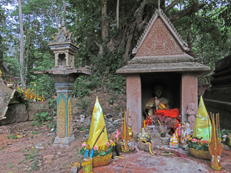 A spirit house and a Buddhist shrine at Wat Preah An Kau Sai in Siem Reap, Cambodia.