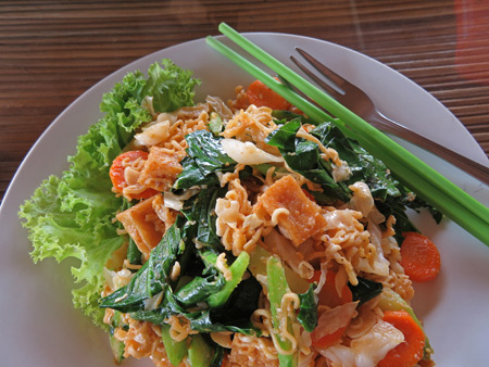 Yellow noodles and vegetables in the Rooftop Cafe at the Golden Takeo Guesthouse in Siem Reap, Cambodia.