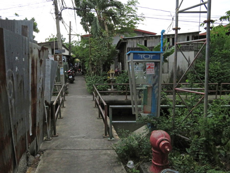 A small bridge crosses a canal in the shantytown maze near the National Museum of Royal Barges in Bangkok, Thailand.