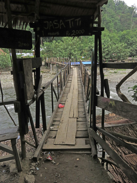 A picturesque wooden bridge crossing the Bohorok river in Bukit Lawang, Sumatra, Indonesia.