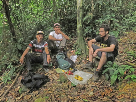 Two local Indonesian guides and Alex take a break in Bukit Lawang, Sumatra, Indonesia.