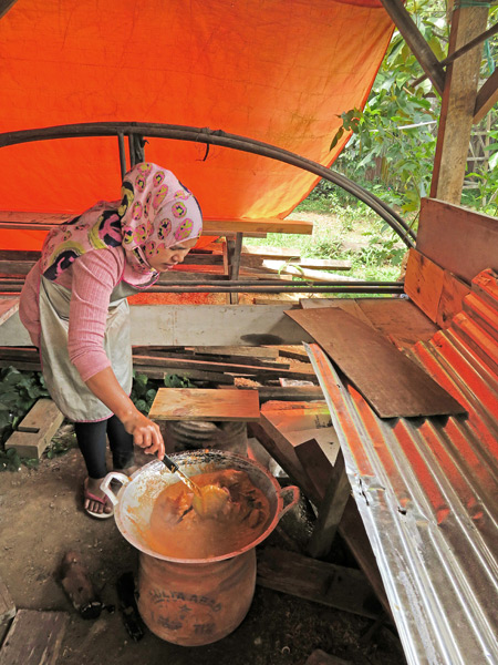 A woman cooks up something delicious in Kiniko, near Bukittinggi, Sumatra, Indonesia.