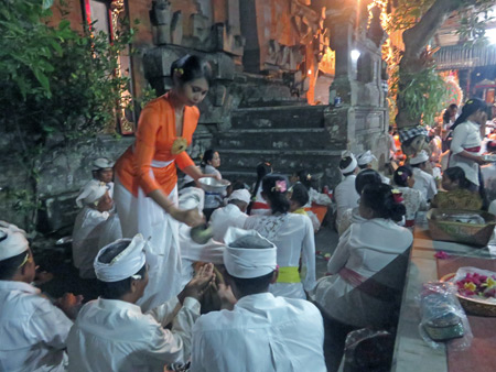 Time for holy water at a Hindu temple ceremony at Pura Penataran Pande in Peliatan, Bali, Indonesia.