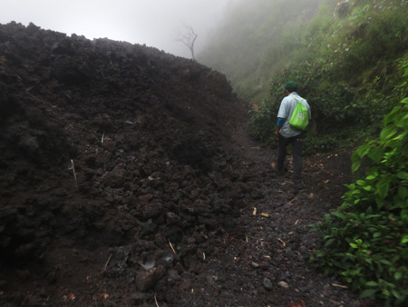 Our guide, Samuel, leads us past a wall of volcanic rock at Pacaya volcano in Guatemala.