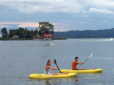 A couple paddles kayaks on Lago Petén Itzá in Flores, Guatemala.