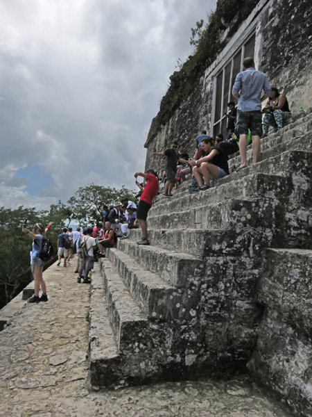 A crowd shoots photos on top of Temple IV at Tikal, Guatemala.