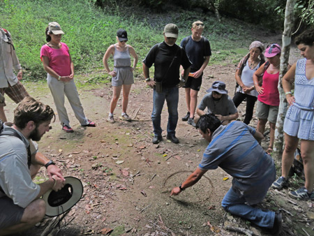 Our guide, Julio, draws a graph in the dirt at Tikal, Guatemala.