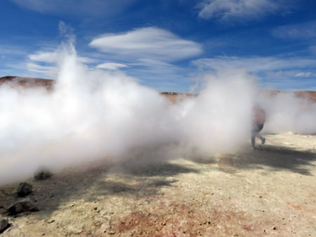 A tourist gets blasted by a column of steam from the main vent at the Geyser Sol de Manana in the Reserva Nacional de Fauna Andina Eduardo Avaroa, Bolivia.
